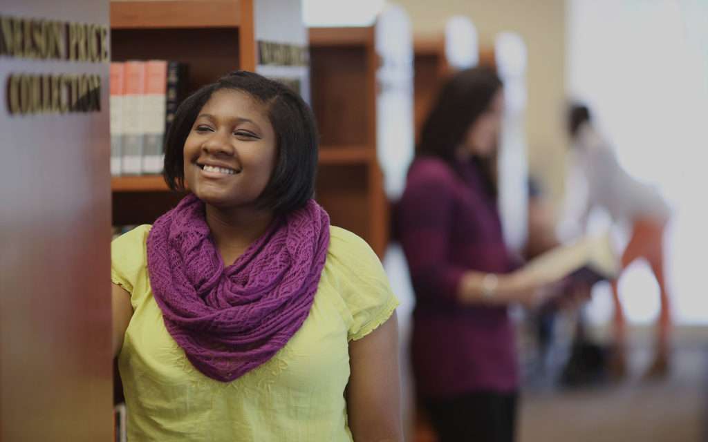 Smiling student choosing library book