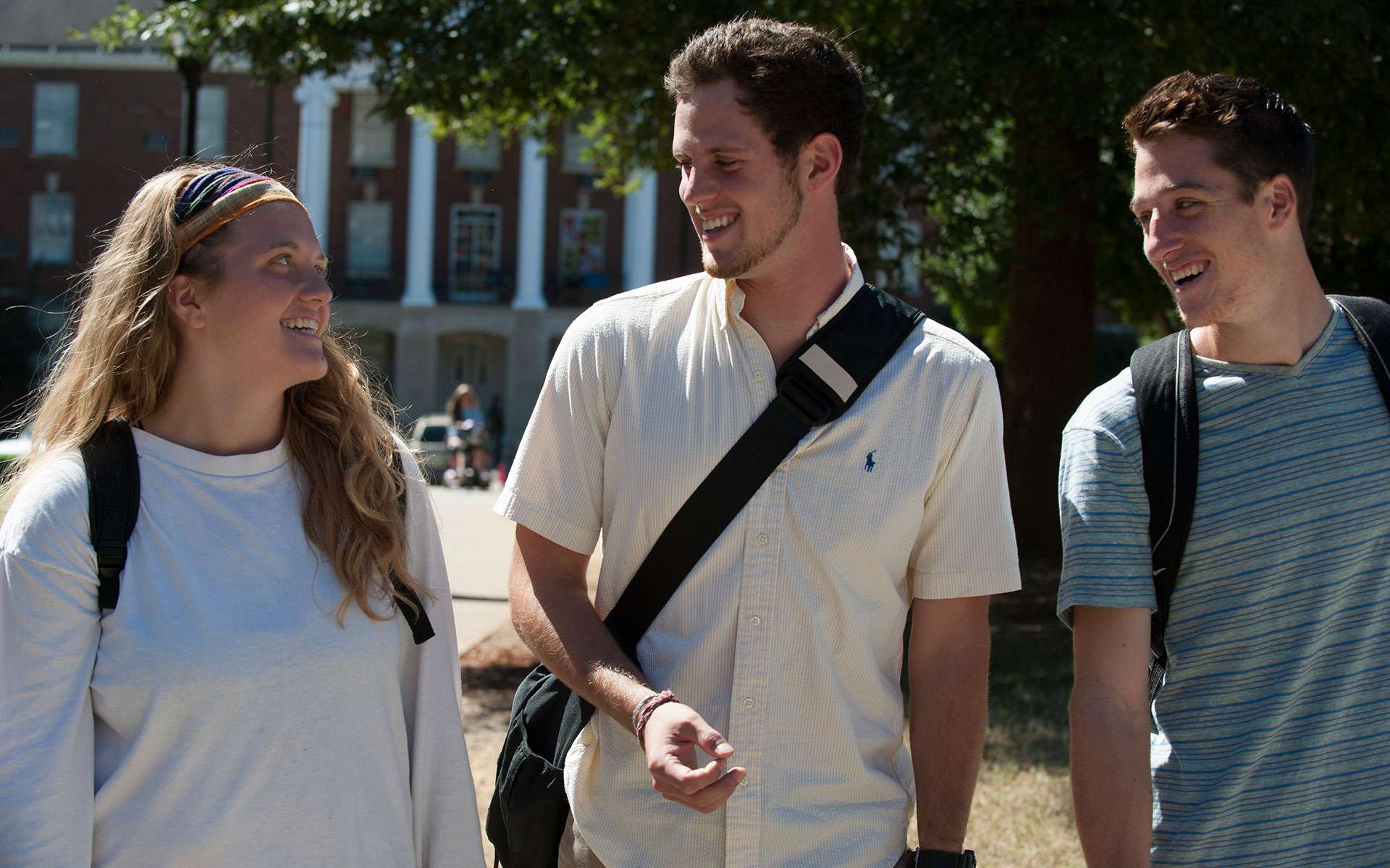 A girl and two boys talking and laughing